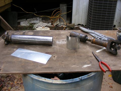 Driveshafts and parts laid out on a wooden workbench.