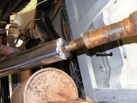 Vehicle driveshaft and muffler, with a welded repair on the driveshaft.