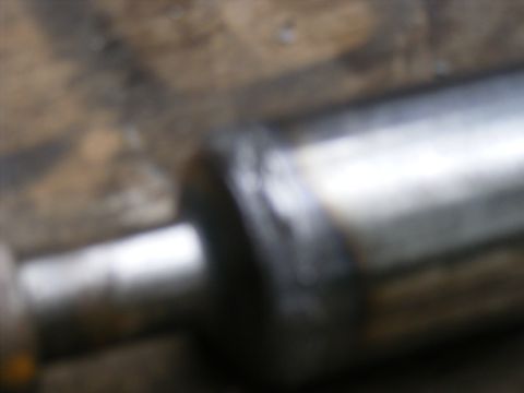 Close-up of a metal rod with a welded joint, blurry.