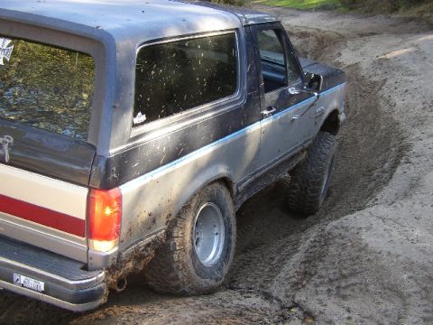1989 Ford Bronco - This 1989 Ford Bronco is navigating a challenging off-road course, with its tires digging into the loose dirt.