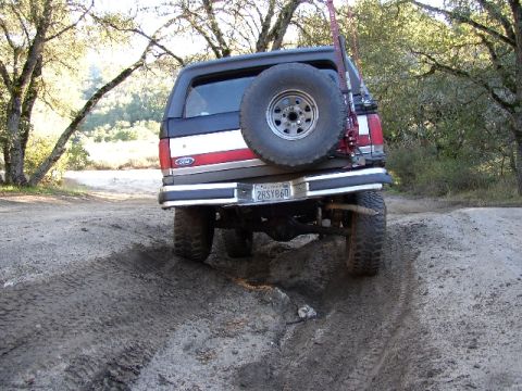 1989 Ford Bronco - This 1989 Ford Bronco is captured from the rear as it maneuvers through a challenging dirt path.