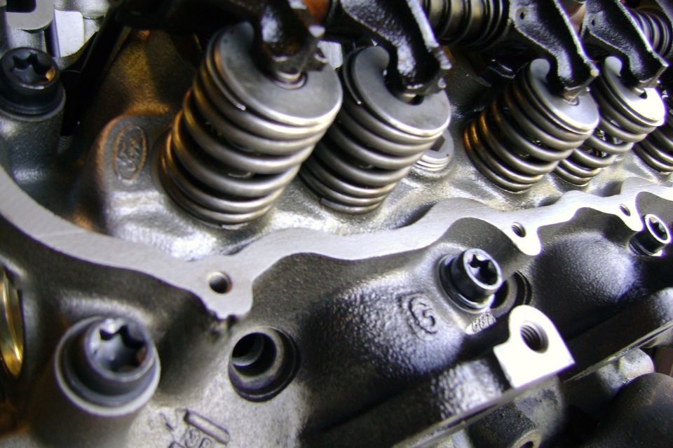 Close-up of an engine cylinder head with valve springs and rocker arms visible