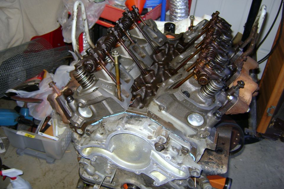 V8 engine block with valve covers removed, showing pushrods and rocker arms