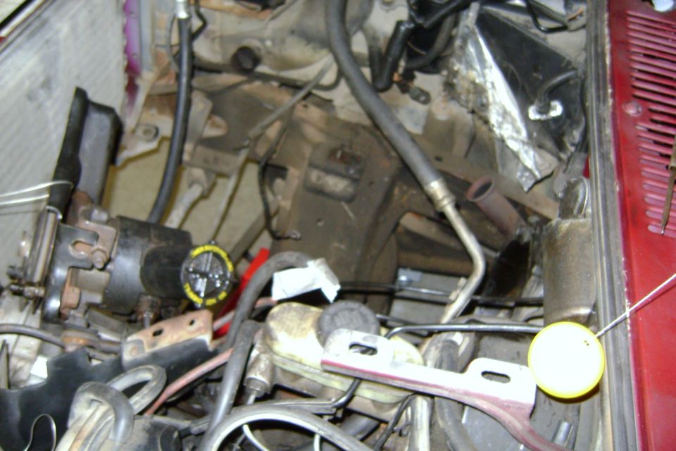 engine bay showing brake master cylinder, hoses, and some engine components