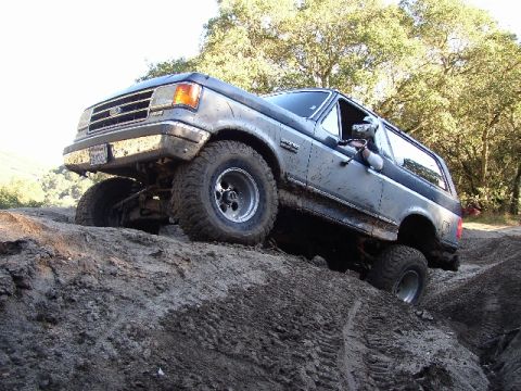 1989 Ford Bronco - This Ford Bronco navigates a steep dirt incline, its off-road capabilities.