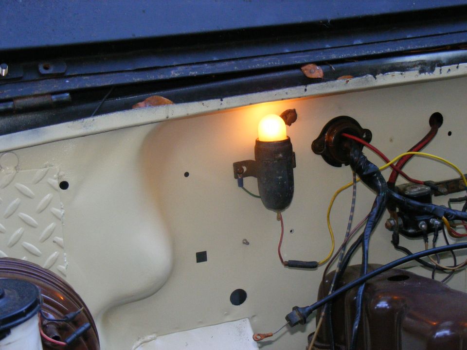 Engine bay with a lit amber indicator light and wiring harness