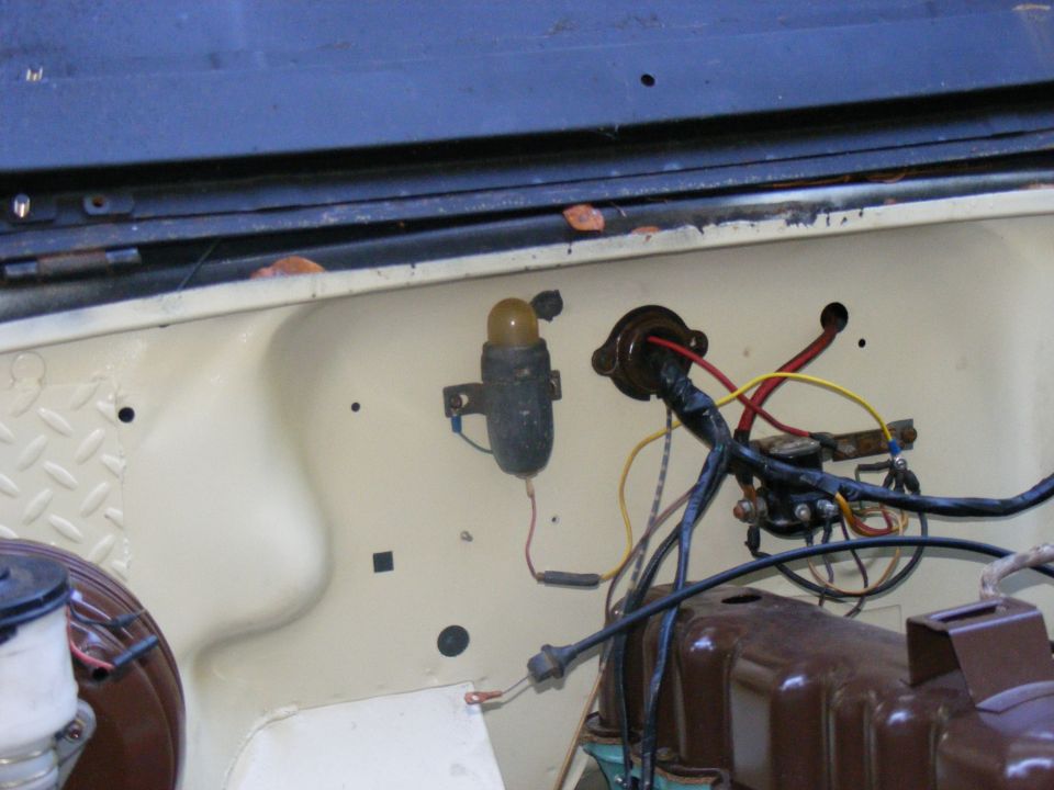 Engine bay wiring with yellow indicator light and brown engine block