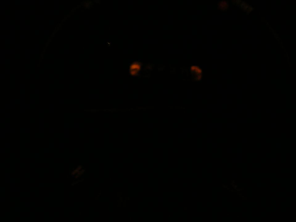 Dashboard lights glow orange in a dark vehicle interior