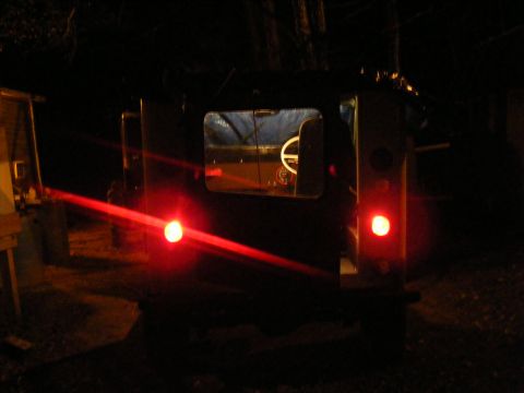 Rear view of a dark-colored SUV with red taillights illuminated