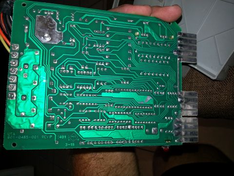 1994 Ford Bronco - A circuit board is held by a hand, showing intricate electronic pathways and connectors.