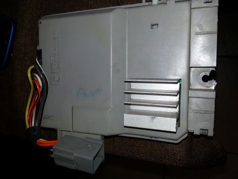 1994 Ford Bronco - Automotive electronic control module with visible wiring and connector. Part of a vehicle's electrical system.