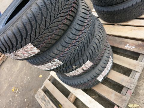 1991 Ford LTD Crown Victoria - Four new tires are stacked on wooden pallets, ready for sale or transport.