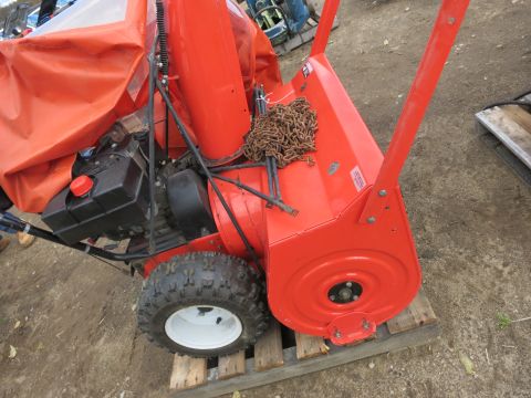 1991 Ford LTD Crown Victoria - An orange snowblower with a chain and engine is shown in this image.