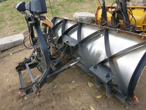 1991 Ford LTD Crown Victoria - A snow plow attachment is shown from the side, a curved metal blade and hydraulic components.
