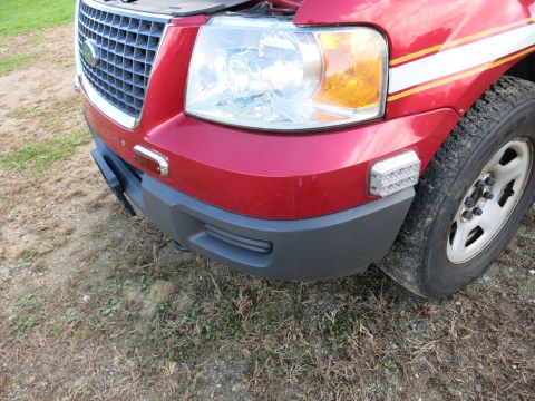 1991 Ford LTD Crown Victoria - Front view of a red Ford Expedition, showing the grille and headlights. Aftermarket lights are installed.