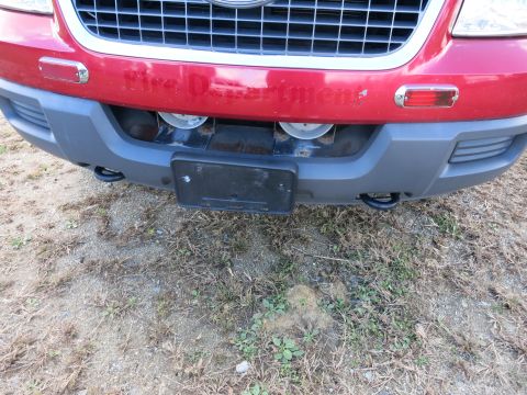 1991 Ford LTD Crown Victoria - The front bumper and grille of a red vehicle with 'Fire Department' text visible.