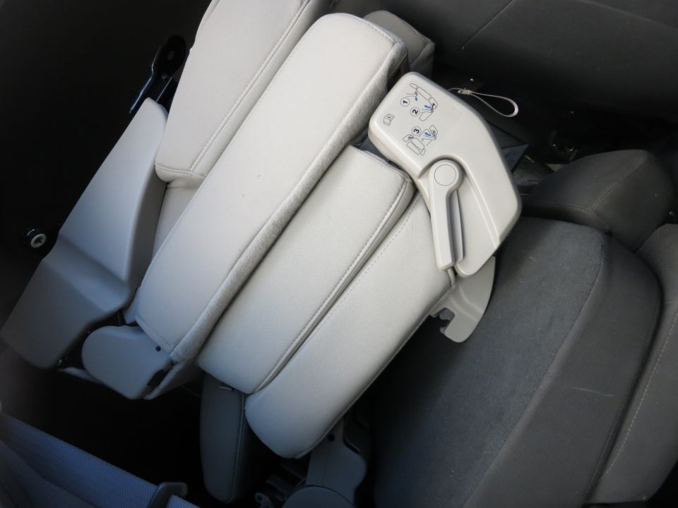 Folded light-colored car seats with a gray seatbelt visible