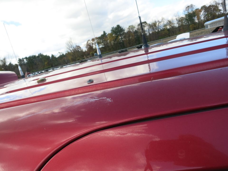 Red vehicle roof with multiple antennas and a scratch