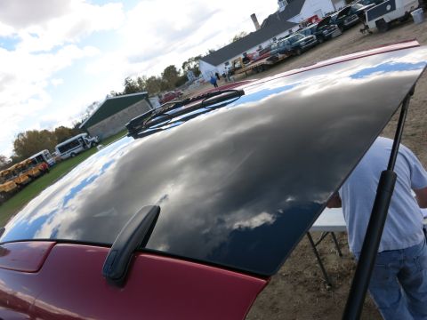 1991 Ford LTD Crown Victoria - The reflective surface of a car hood shows a cloudy sky. Other vehicles are visible in the background.