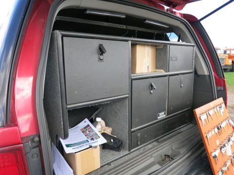 1991 Ford LTD Crown Victoria - The rear interior of a red SUV is filled with storage drawers and a board displaying numerous keys.