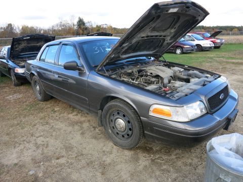 1991 Ford LTD Crown Victoria - Two Ford Crown Victorias parked outside, hoods up, one with '317' on windshield.
