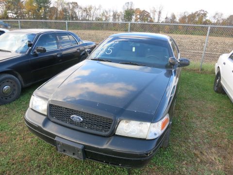 1991 Ford LTD Crown Victoria - A black 1991 Ford Crown Victoria LTD is parked outdoors next to another vehicle, with a white '15' visible on its windshield.