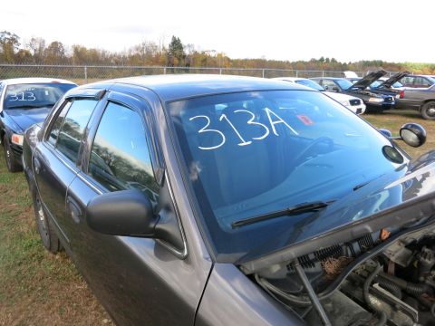 1991 Ford LTD Crown Victoria - A dark gray Ford Crown Victoria is parked in an outdoor lot with other vehicles.