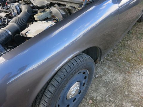 1991 Ford LTD Crown Victoria - Close-up view of the front fender and engine compartment of a Ford Crown Victoria.