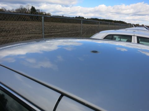 1991 Ford LTD Crown Victoria - A row of cars are parked in an outdoor lot under a cloudy sky.