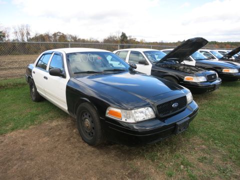 1991 Ford LTD Crown Victoria - Several Ford Crown Victorias are parked in a lot, one with its hood open.