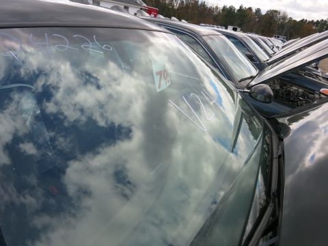 1991 Ford LTD Crown Victoria - Multiple dark sedans are lined up, with handwritten markings on the windshields and a price tag visible on one.