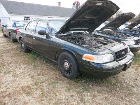 1991 Ford LTD Crown Victoria - Several Ford Crown Victorias are lined up with their hoods open, showing their engines.