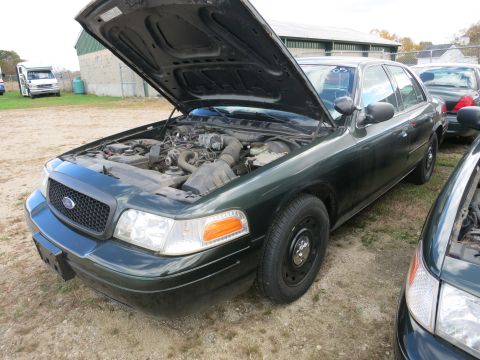 1991 Ford LTD Crown Victoria - A dark green Ford Crown Victoria sedan is parked outdoors with its hood open, revealing the engine compartment.