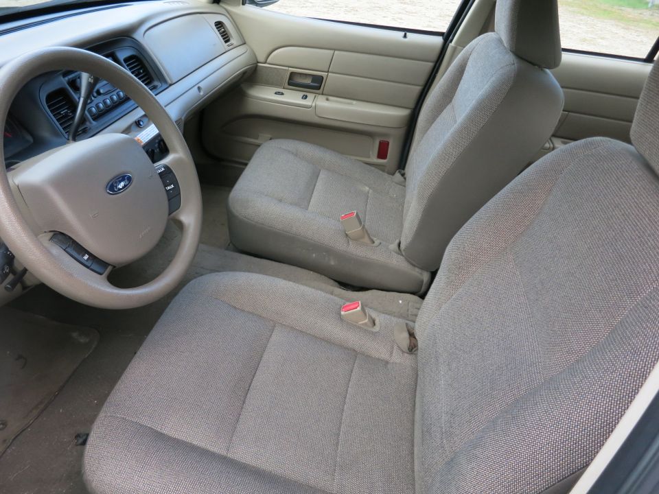 Interior of a 2003 Ford Crown Victoria showing front seats, steering wheel, and dashboard