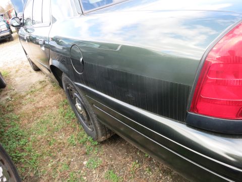 1991 Ford LTD Crown Victoria - This 1991 Ford Crown Victoria LTD is shown from the side, highlighting its dark green paint and classic sedan body style.
