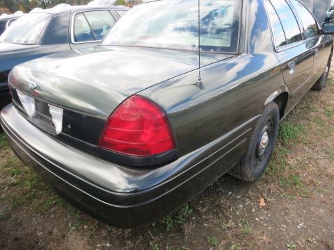 1991 Ford LTD Crown Victoria - Rear view of a dark green sedan, parked outdoors with another car visible.