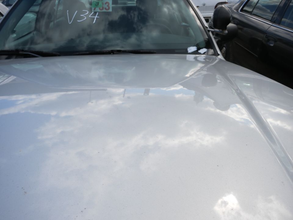 Silver car hood and windshield with V34 written on glass