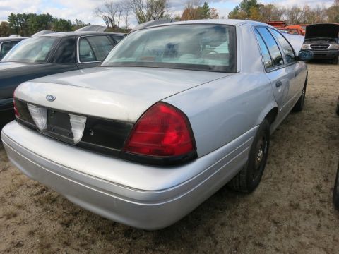 1991 Ford LTD Crown Victoria - A silver sedan is parked in a lot with other vehicles, viewed from the rear.