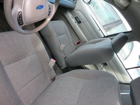 1991 Ford LTD Crown Victoria - Interior view of a car's front seats and steering wheel, showing fabric upholstery and seat belts.