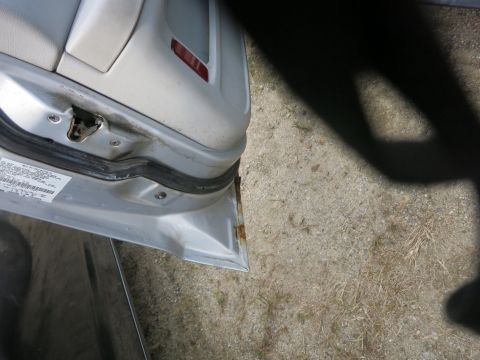 1991 Ford LTD Crown Victoria - Close-up view of a car's interior door frame, showing signs of wear and rust.