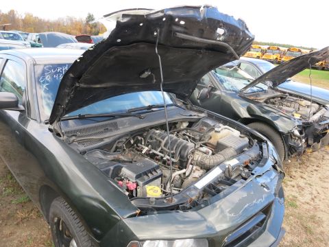 1991 Ford LTD Crown Victoria - Photograph of a sedan engine bay at a surplus lot, not a technical document.