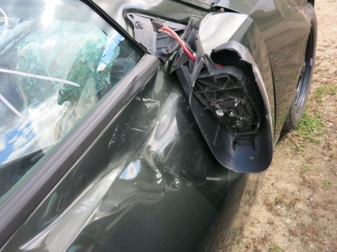 1991 Ford LTD Crown Victoria - Photograph of a sedan's damaged side mirror mount, not a technical document.