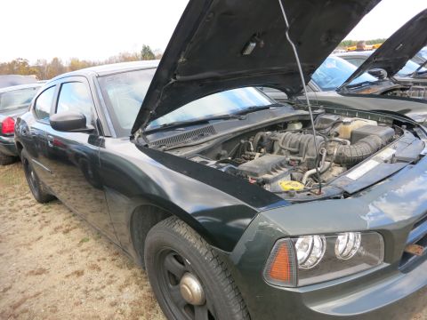 1991 Ford LTD Crown Victoria - Photograph of a sedan engine bay at a surplus lot, not a technical document.