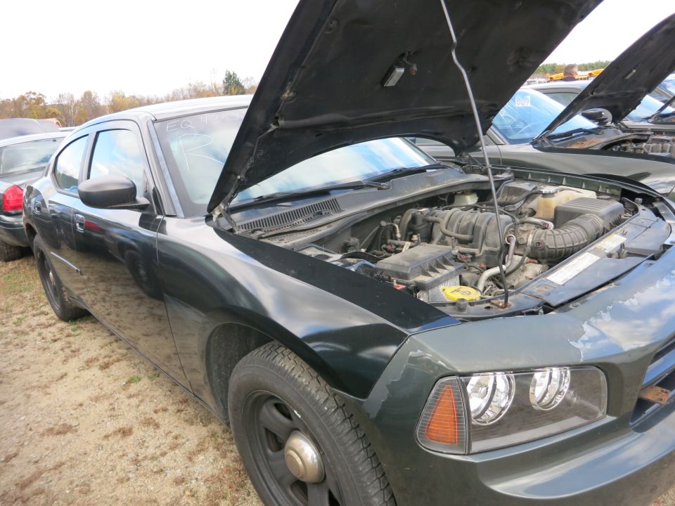 Sedan with hood open showing engine compartment at an outdoor lot