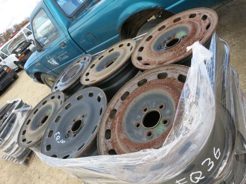 1991 Ford LTD Crown Victoria - Photograph of steel wheels stacked on a pallet, not a technical document.