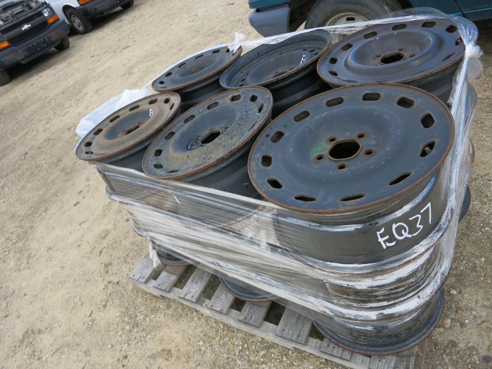 Pallet of stacked steel wheels marked EQ37 at an outdoor yard