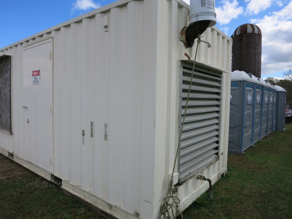 White container generator enclosure with louvered vent in a field