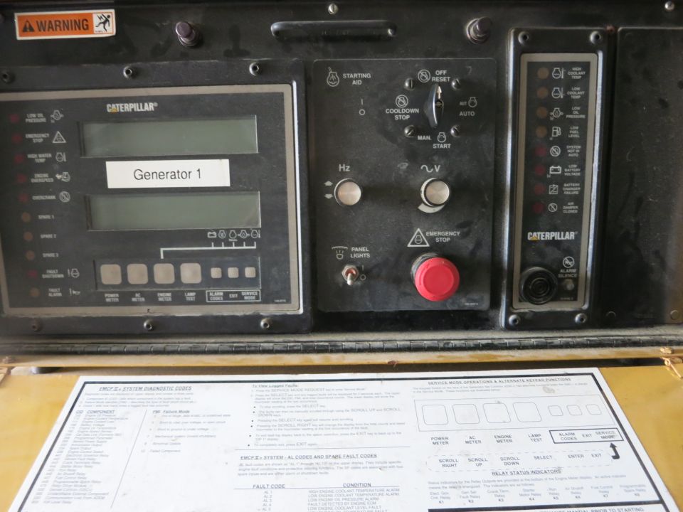 Caterpillar generator control panel above a system diagnostic codes chart