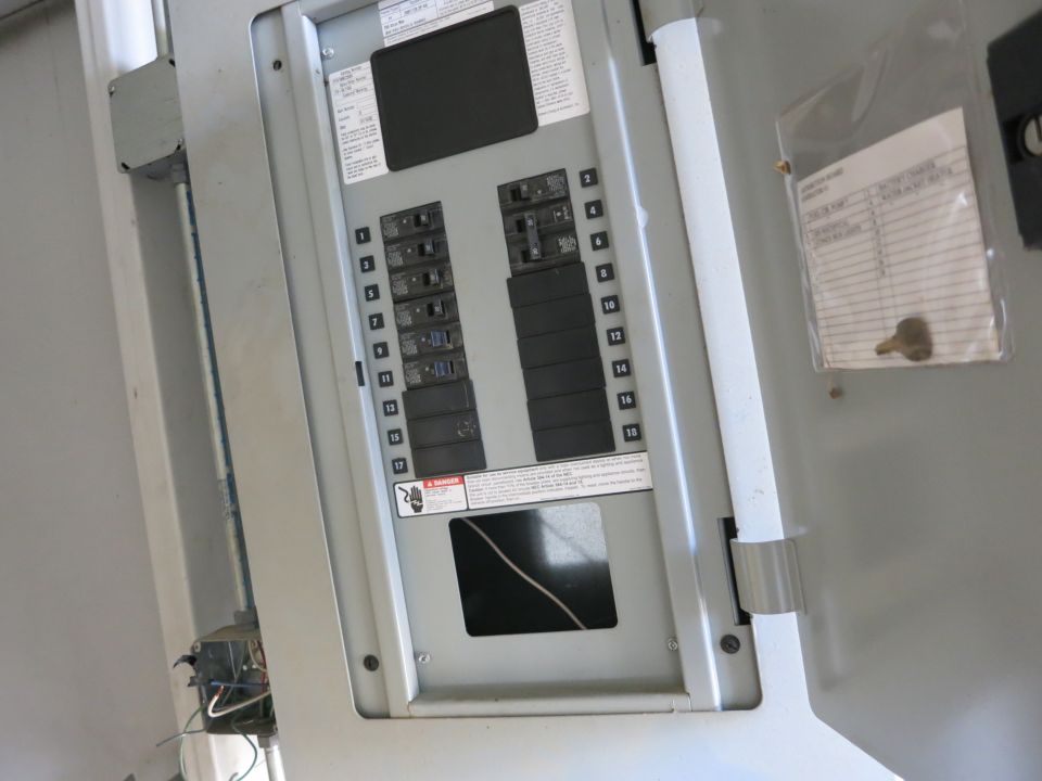 Open electrical breaker load-center panel with numbered circuit breakers