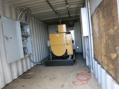 1991 Ford LTD Crown Victoria - Photograph of a generator set installed inside a shipping container alongside electrical panels, not a document.